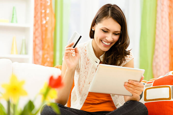 Woman holding a tablet and a credit card